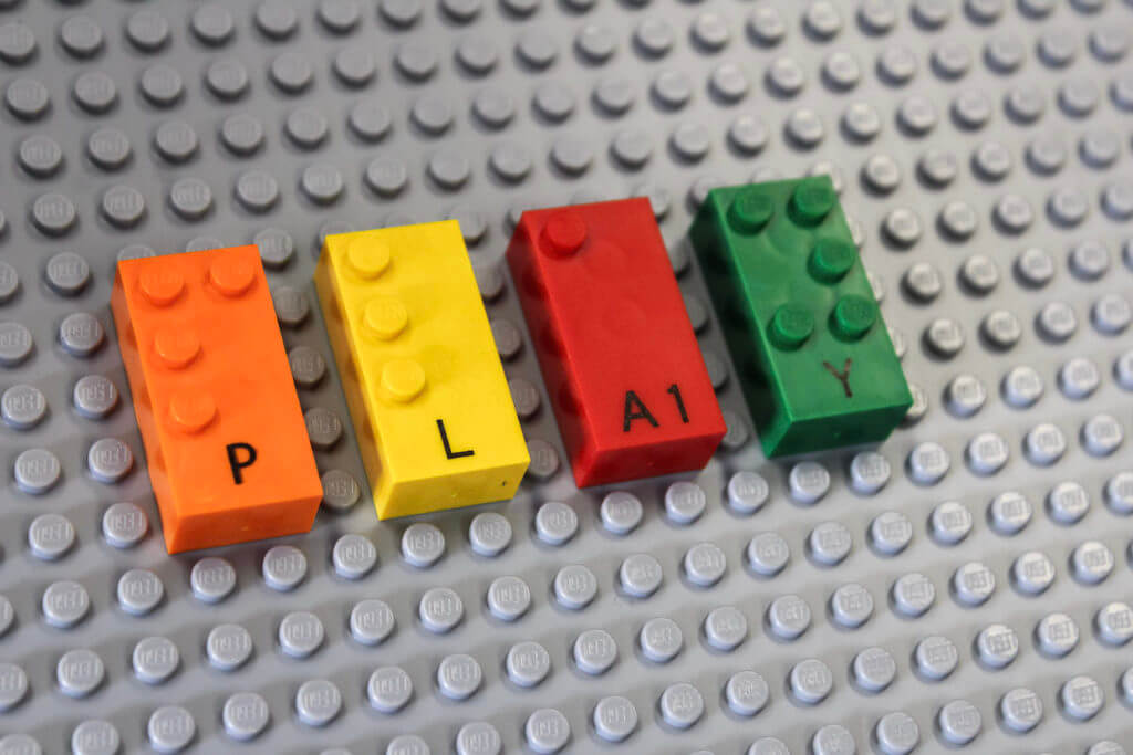 Mattoncini LEGO Braille colorati formano la scritta PLAY