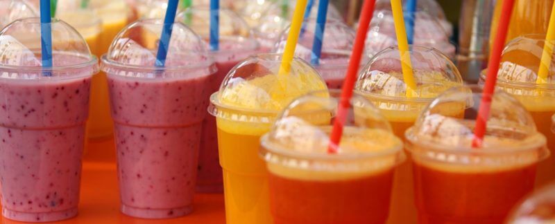 frullati di frutta in bicchieri di plastica con cannucce di plastica